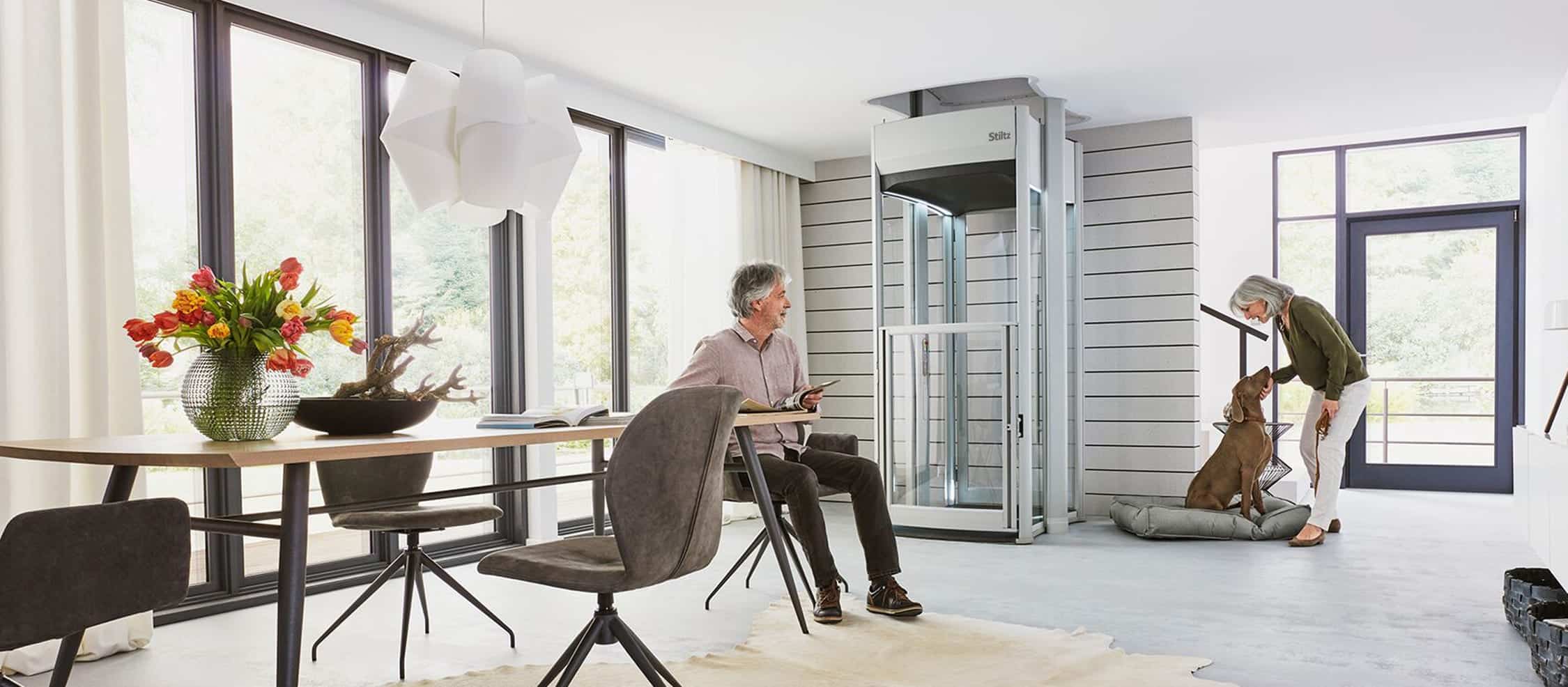 Couple using a Stiltz home lift in their living room